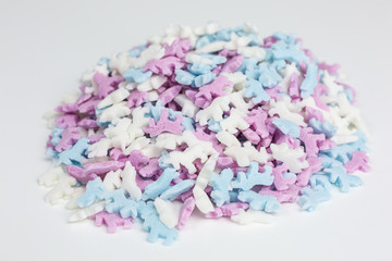 heap of colorful unicorn sugar sprinkles in white, pink and blue