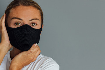 A young woman wears a protective mask against the spread of the virus. Staying at home, self-isolation, coronavirus