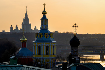 Silhouettes of buildings in the setting sun in a city landscape
