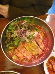 A dish of Korean spicy sauce mixed with noodles and topped with pork cutlet.