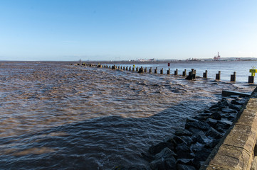 erosion tide rising over a jetty