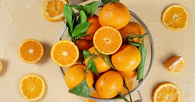 Ripe tangerines in a colander slowly rotate.