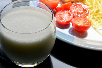 a glass of ayran with meatballs and spaghetti 