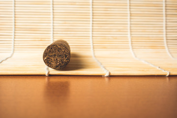 Good cigar on white bamboo mat.