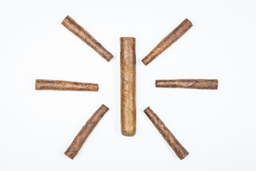 The sun laid out of twisted cigars on white background.