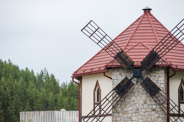 Windmill with large blades for grinding grain.