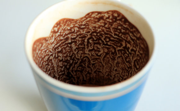 close-up residues of coffee grounds in the cup in the form petroglyphs or brown pattern for divination and foretelling the future