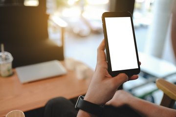 Close up of man using blank cell phone order products for shopping online within the cafe.