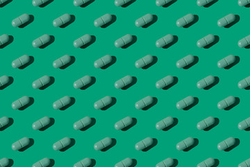 green monochrom flat lay composition with green tablets or pills, creative layout