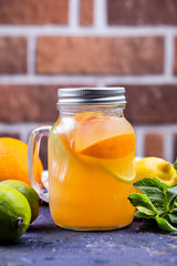 Cold citrus fruit lemonade in jar with orange , lime and lemon