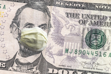 Close up of United States paper currency five dollar bill with Abraham Lincoln wearing yellow...