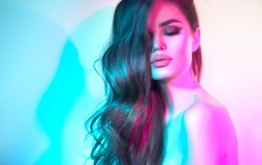 High Fashion model woman in colorful bright neon lights posing in studio, night club. Portrait of...