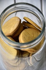 gluten-free biscuits with rice flour and honey in glass jar on a white background
