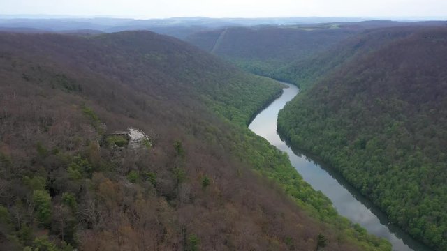 Aerial view trucking to the left and turning keeping the Coopers Rock overlook with panoramic views of the surrounding mountains and river.