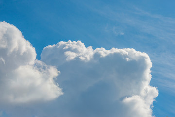 White cumulus clouds from thermals in a blue sky in sunlight in spring