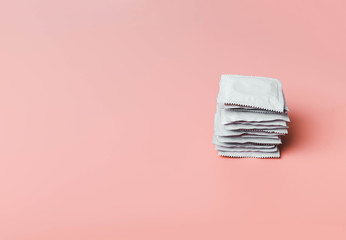 Condom on a pink background. The concept of safe sex, stopping the transmission of sexually transmitted diseases, STDs, AIDS - obrazy, fototapety, plakaty