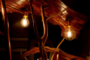 part of a handmade wooden floor lamp with LED lamps stylized as Edison lamps. Stylish piece of furniture