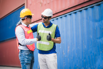 Young man Engineer and worker Thumbs up Check and control loading freight logistic Containers at commercial shipping dock smiling felling good and happy. Cargo freight ship import export concept