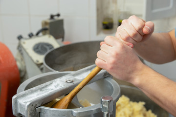 Hands preparing and kneading gnocchi with machine