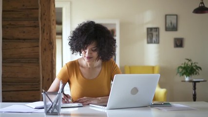 woman writing notebook from laptop. Spbd biracial girl student distant learning on quarantine isolated. university female studying online concentated. concept education - Powered by Adobe