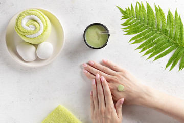 woman applying natural scrub to her hand. hand massage, skin exfoliation. white background with...
