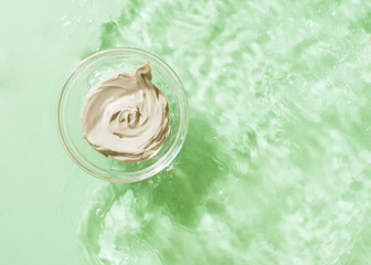 Natural organic cosmetic product, glasee water transparent, top view on mint green background