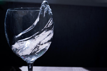 splash of water in a glass in cold dark light