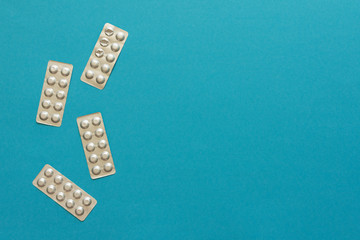 Blister packs with pills on a blue background, lowering blood cholesterol with statin tablets