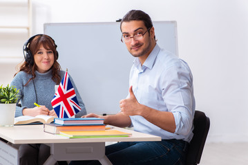 Young female student and male english teacher in the classroom