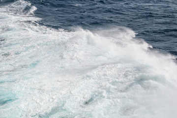 Ocean wave with a cap of sea foam in windy weather. Background. Abstract.