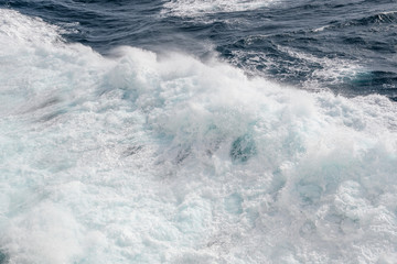 Naklejka premium Ocean wave with a dense cap of sea foam in stormy weather. Background. Abstract.
