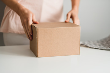 Woman holding a cardboard box, the parcel in hands. Delivery concept, mock up.