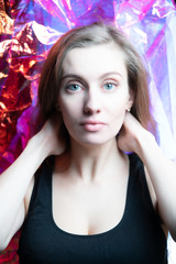 Portrait of a beautiful model girl in the studio, in shiny foil shimmering in different colorsPortrait of a beautiful model girl in the studio, in shiny foil shimmering in different colors