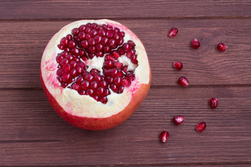 ripe cleaned pomegranate on a wooden background