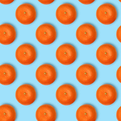 Seamless pattern of tangerines isolated on a blue table. Mandarins. Food background