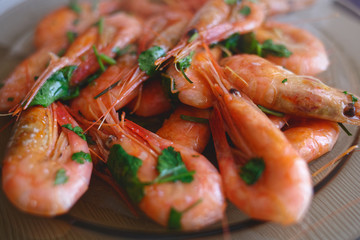Delicious prawns with coriander in a plate on the table. Fresh seafood dish close-up