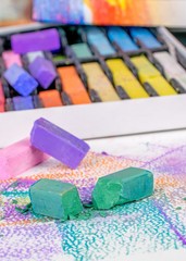  A close up macro image of broken artists soft pastel chalk crayons on an art pad