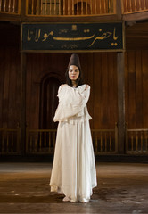 Portrait for a Sufi whirling woman dancer wearing white dress (Turkish/Semazen) performing art of Sama or physically active meditation of Sufism, and during spiritual dancing performance at Egypt