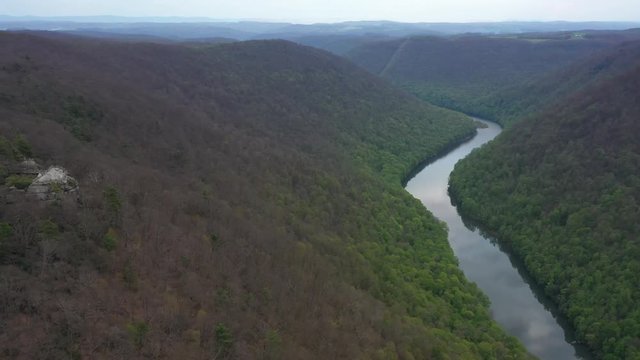 Aerial view trucking to the left and turning keeping the Coopers Rock overlook with panoramic views of the surrounding mountains and river.