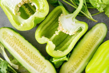 green pepper, cucumber  on a gray , green vegetables and herbs close up