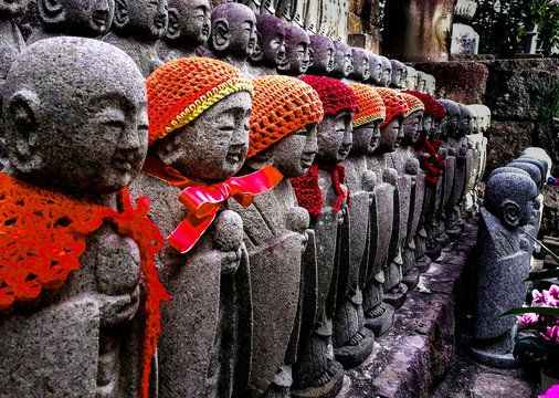 Stone Buda with scarf and wool hat in a budist temple from Japan.