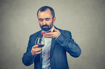 man smelling a glass of wine, man wine feeling his aroma in studio