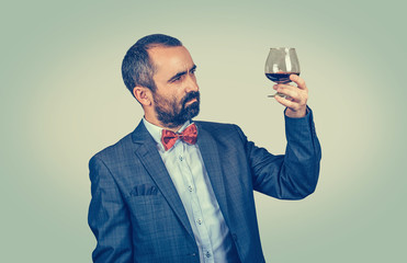  sommelier looking at the glass of wine, to it color