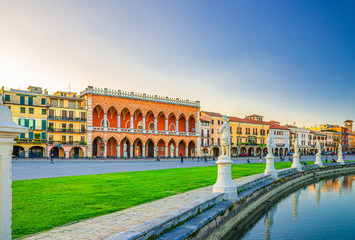 Padua cityscape with Palazzo Loggia Amulea palace neogothic style building and statues near small canal on Piazza Prato della Valle square in historical city centre, Padova town, Veneto Region, Italy