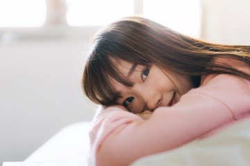 Portrait young asian cute student woman pink sweater at bedroom