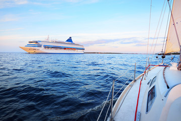 Large white cruise liner (passenger ship) sailing in the Riga bay of the Baltic sea at sunset. A...