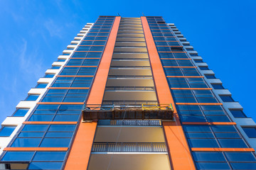 Top view Suspended elevator on a high residential building under construction, decoration of the facade and windows.