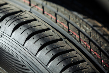 Tread of a new car tire at a car dealership. Close-up