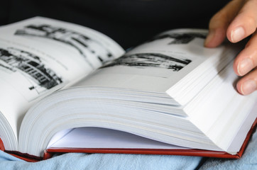 Grandfather reads a book and turns the page.