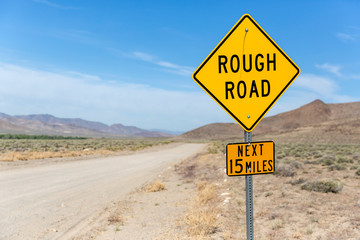 Yellow sign warns of rough country road going across the nevada desert